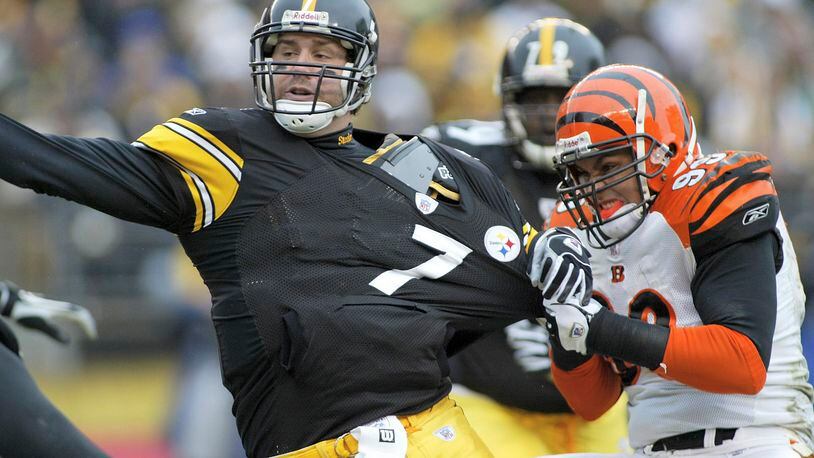 PITTSBURGH, PA- DECEMBER 4: Ben Roethlisberger #7 of the Pittsburgh Steelers throws the ball away as David Pollack #99 of the Cincinnati Bengals tries to sack him on December 4, 2005 at Heinz Field in Pittsburgh, Pennsylvania. (Photo by Rick Stewart/Getty Images)