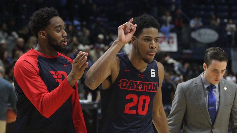 Dayton’s Josh Cunningham and Xeyrius Williams celebrate a victory against Rhode Island on Friday, Feb. 10, 2017, at the Ryan Center in Kingston, R.I. David Jablonski/Staff