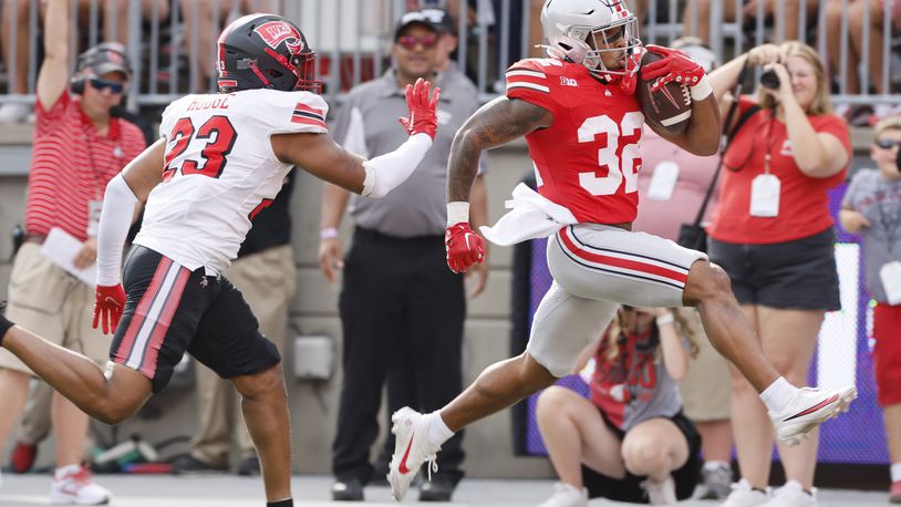 Ohio State running back TreVeyon Henderson, right, runs past Western Kentucky linebacker Rashion Hodge to score a touchdown during the first half of an NCAA college football game, Saturday, Sept. 16, 2023, in Columbus, Ohio. (AP Photo/Jay LaPrete)