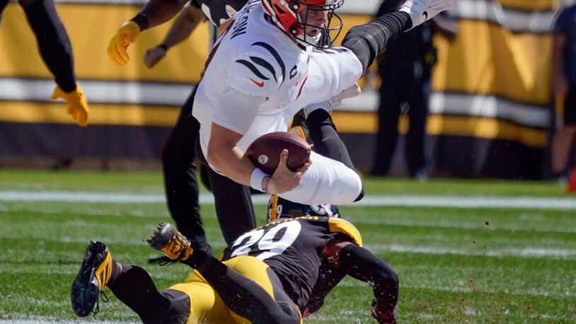Cincinnati Bengals quarterback Joe Burrow (9) tumbles over Pittsburgh Steelers free safety Minkah Fitzpatrick (39) after scrambling for a first down during the first half an NFL football game, Sunday, Sept. 26, 2021, in Pittsburgh. (AP Photo/Gene J. Puskar)