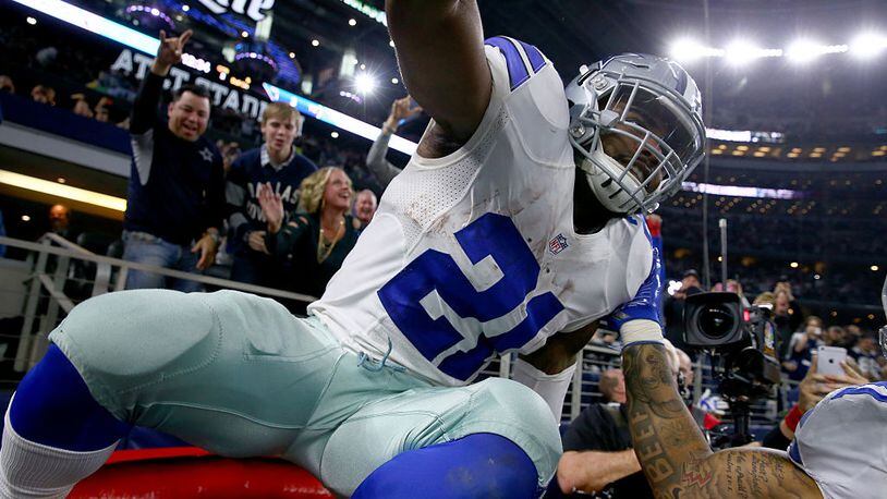 ARLINGTON, TX - DECEMBER 18: Ezekiel Elliott #21 of the Dallas Cowboys celebrates after scoring a touchdown by jumping into a Salvation Army red kettle during the second quarter against the Tampa Bay Buccaneers at AT&T Stadium on December 18, 2016 in Arlington, Texas. (Photo by Tom Pennington/Getty Images)