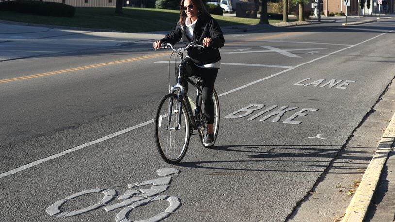 Cathy Blakeley rides her bicycle in the bike lane that runs along South Center Street in Springfield Tuesday, Oct. 4, 2022. BILL LACKEY/STAFF