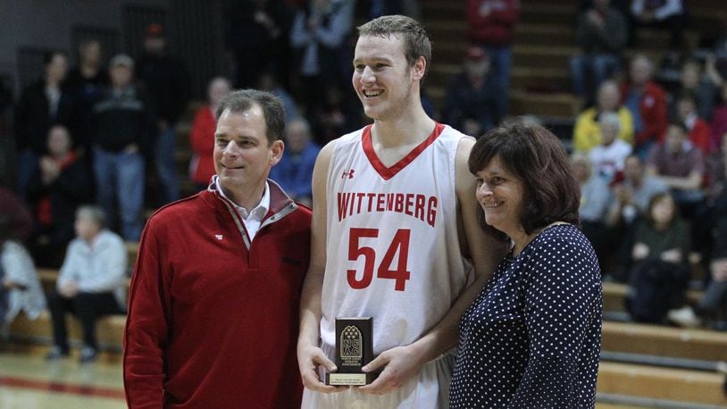 Wittenberg’s Connor Seipel, center, holds the NCAC tournament MVP trophy as he poses for a photo with Wittenberg President Michael Fransden and NCAC Executive Director Keri Alexander Luchowski after a victory against Ohio Wesleyan on Saturday, Feb. 24, 2018, at Pam Evans Smith Arena in Springfield. David Jablonski/Staff