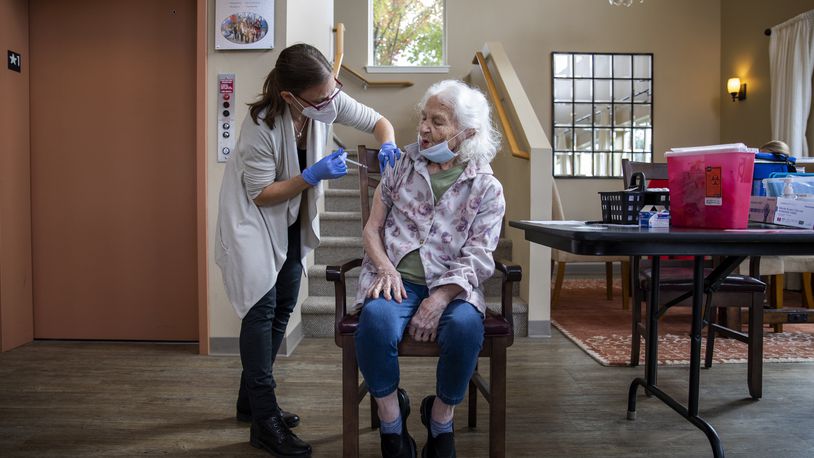 FILE - A health care worker administers a COVID-19 vaccine to a patient at a senior living center in McMinnville, Ore., Oct. 6, 2021. Recipients of the Moderna and the J.&J. vaccines may receive extra doses, the committee said, although the shots continue to prevent illness and death. (Alisha Jucevic/The New York Times)