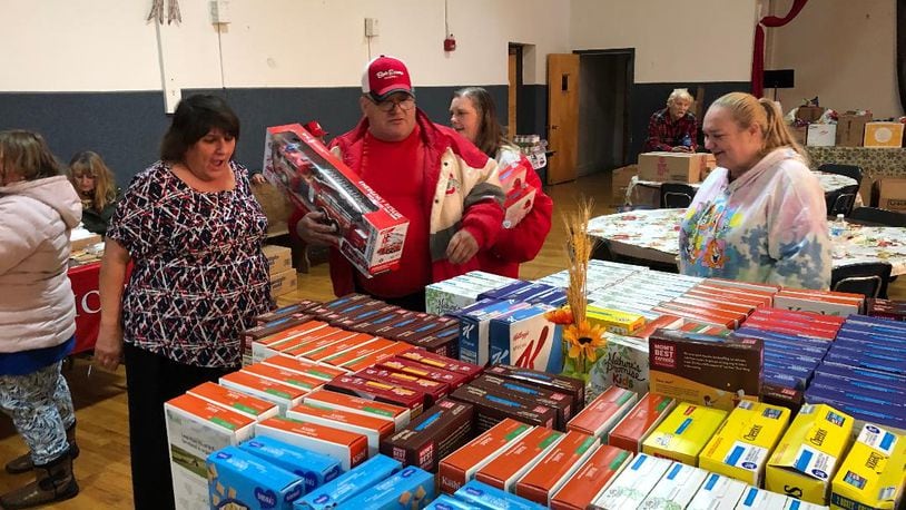 Victory Faith Center Pastor Pauline Hamblin helps a family select items to help this holiday seasons during a giveaway event that saw hundreds of toys and food items passed to the city's needy. Phioto by Brett Turner