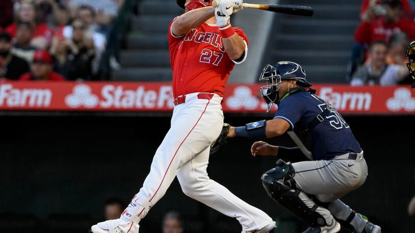 Los Angeles Angels' Mike Trout follows through on a two-run home run next to Tampa Bay Rays catcher Rene Pinto during the first inning of a baseball game in Anaheim, Calif., Tuesday, April 9, 2024. (AP Photo/Alex Gallardo)