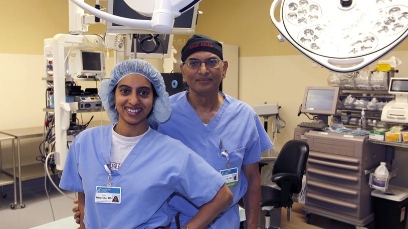 Dr. Surender Neravetla and Dr. Soumya Neravetla pose together in an operating room at the Springfield Regional Medical Center. Soumya has been working with her father in Springfield for the past several months. Bill Lackey/Staff