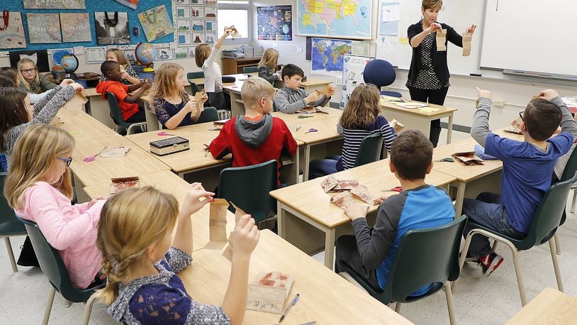 A third grade class at Miami View Elementary makes turkeys out of paper bags Tuesday. Southeastern report card did better than some other schools this year. Bill Lackey/Staff