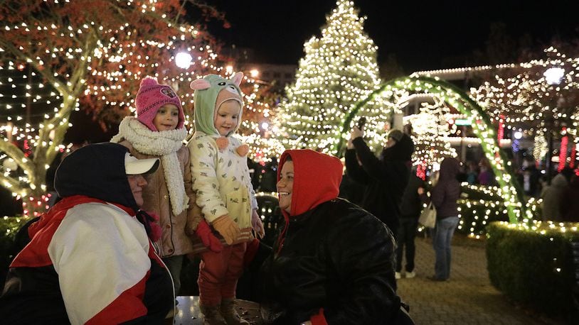 A family poses for a picture on the Springfield Esplanade during the Grand Illumination Friday evening. BILL LACKEY/STAFF