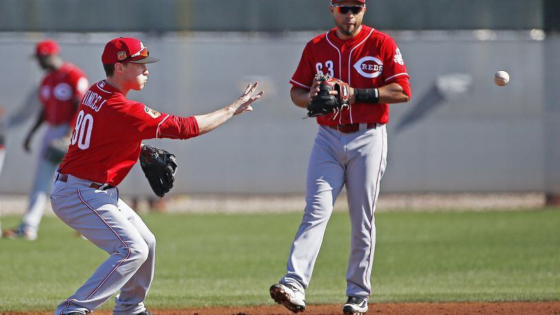 Cincinnati Reds infielder Zach Vincej flips the ball to second base as Hernan Iribarren looks on. Vincej, a former Dayton Dragon, is in the mix for a utility role. AP photo