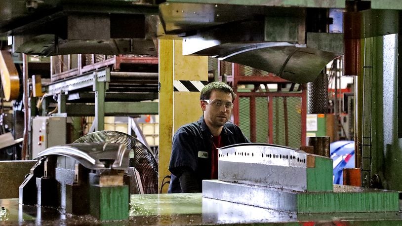 Josh Studebaker, an employee of Pentaflex, operates a press on the manufacturing floor Friday. BILL LACKEY/STAFF