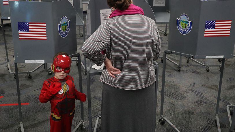 Emery Lowe, 5, aka The Flash, keeps an ever watchful eye on the election poll at the Champaign County Government Center Tuesday as his grandmother fills out her ballot. BILL LACKEY/STAFF