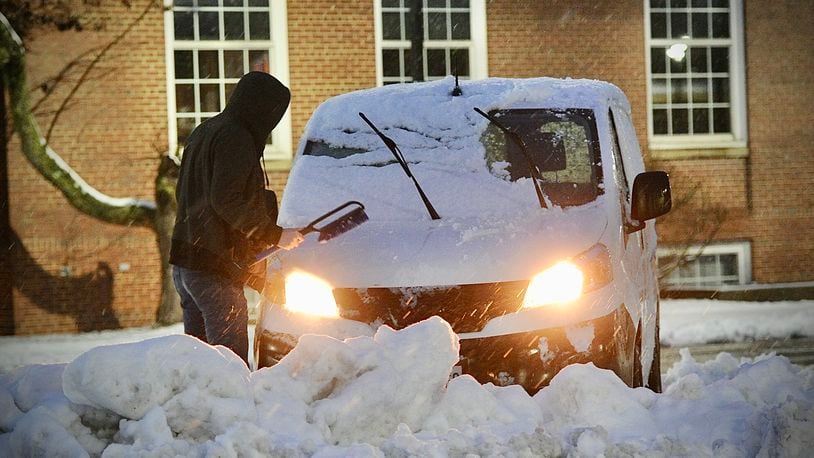 A Fairborn resident remove snow from his vehicle in downtown Fairborn early Wednesday morning, January 25, 2023 MARSHALL GORBY\STAFF