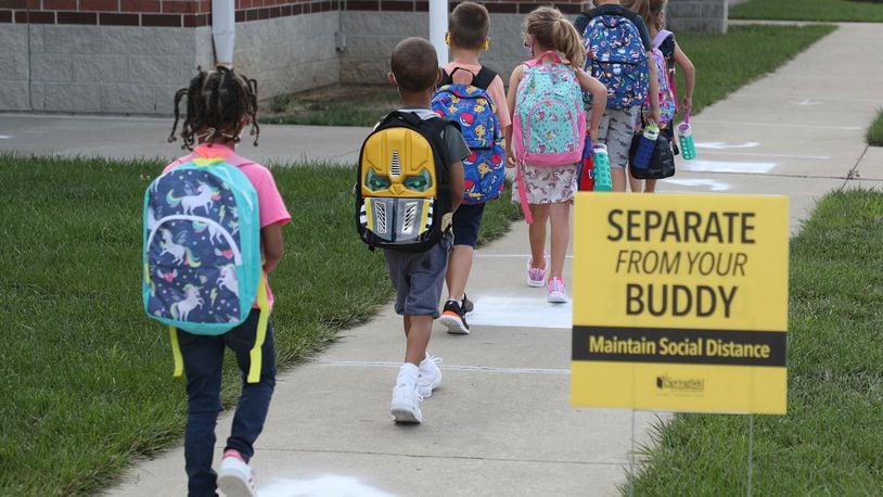 Students practice social distancing as they walk into Simon Kenton in Springfield on the first day of school last month. Springfield City Schools is one of three districts in Clark and Champaign counties reporting COVID-19 cases this week. BILL LACKEY/STAFF