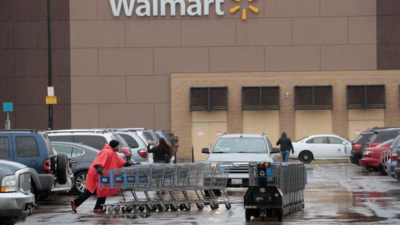 A worker collects shopping carts outside Walmart store on in Chicago, Illinois.