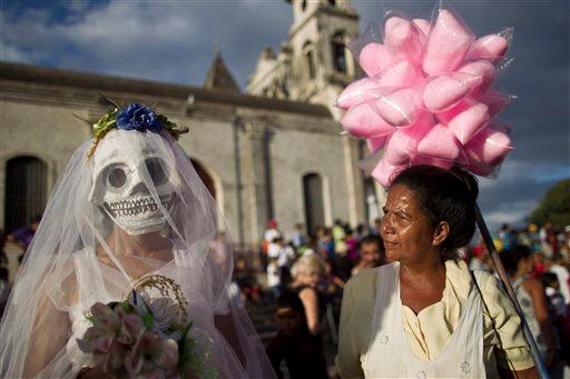 A street vendor, right, looks at a disguised reveler during celebrations marking the 9th International Poetry Festival.