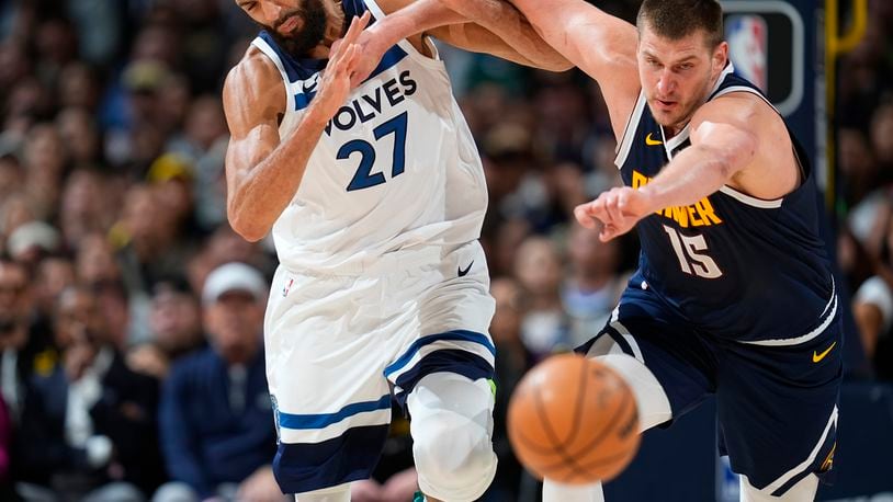 Denver Nuggets center Nikola Jokic, right, pushes Minnesota Timberwolves center Rudy Gobert while they pursue the ball during the second half of an NBA basketball game Wednesday, April 10, 2024, in Denver. (AP Photo/David Zalubowski)