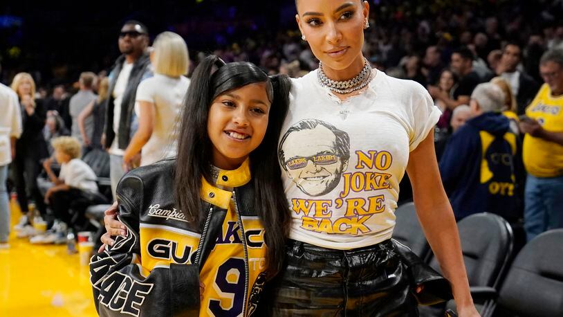 FILE - Kim Kardashian poses for a photo with daughter North West before Game 6 of an NBA basketball Western Conference semifinal series against the Golden State Warriors in Los Angeles on May 12, 2023. West sill join the cast of A starry “Lion King” concert, that is set to run May 24-25 at the Hollywood Bowl. (AP Photo/Ashley Landis, File)