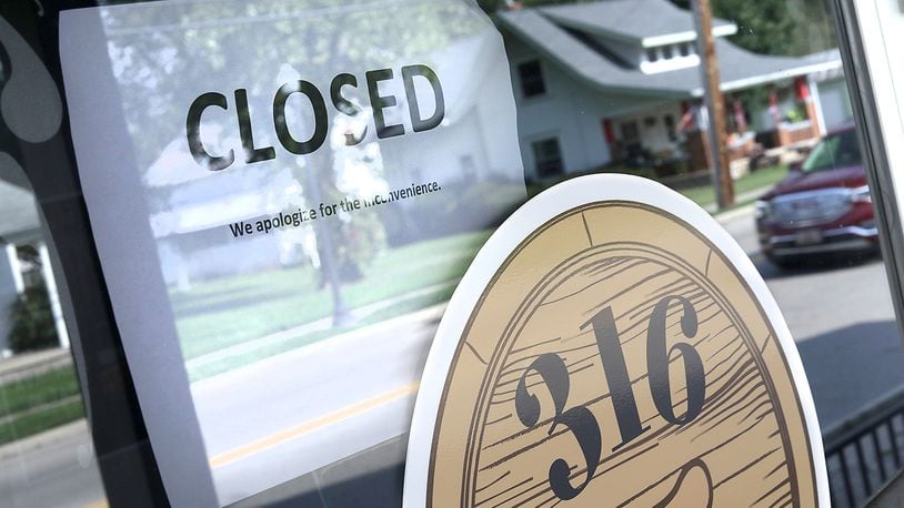 A closed sign on the front door of the 316 Tap & Barrel Grill in Medway. BILL LACKEY/STAFF