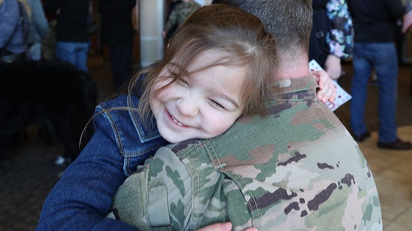 Emelyn Willis, 4, hugs her daddy Maj Aaron Willis during a Welcome Home Ceremony Saturday for the Ohio National Guard’s 371st Sustainment Brigade, headquartered in Springfield.