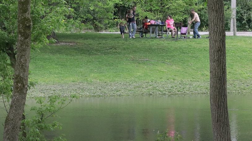 Clark County Health Commissioner is encouraging residents to maintain social distancing standards as they observe the Memorial Day weekend with activities like this family having a picnic along Buck Creek in Snyder Park Friday. BILL LACKEY/STAFF