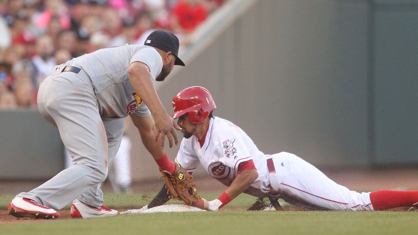 The Reds’ Billy Hamilton slides into third base ahead of a tag by the Cardinals’ Jhonny Peralta on Wednesday, June 8, 2016, at Great American Ball Park in Cincinnati. David Jablonski/Staff
