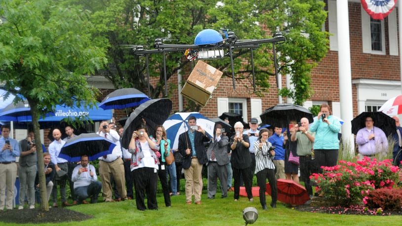 The Kroger Co. took flight with its first retail drone delivery Wednesday morning, June 9, 2021 in Centerville, flying a box containing two packages of long-grain rice and a piece of wood from the first Wright Brothers Flyer to Centerville Mayor Brooks Compton on the front lawn of city offices on West Spring Valley Pike. MARSHALL GORBY\STAFF
