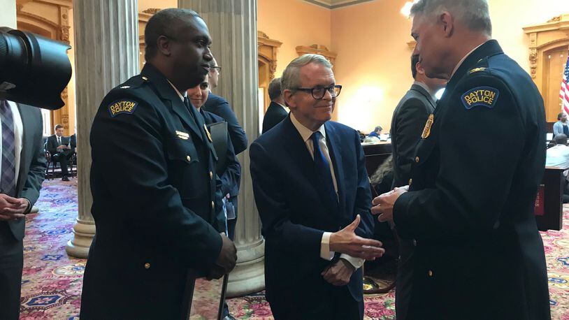 Governor DeWine talks with Dayton Police Chief Biehl and Assistant Police Chief Henderson before they received accommodation during the Ohio Senate meeting on Wednesday. STAFF PHOTO / SARAH FRANKS