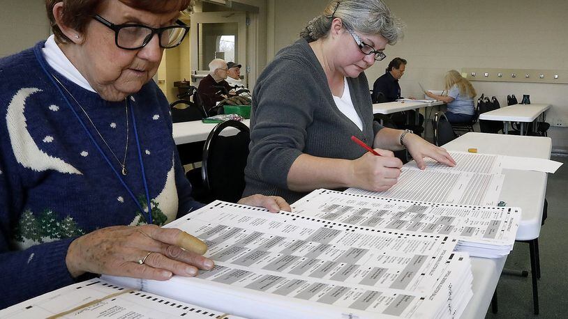 Pat Golden, left, and Sherri Dunsmuir count ballots by hand on Dec. 15 during the election audit at the Clark County Board of Elections. Bill Lackey/Staff