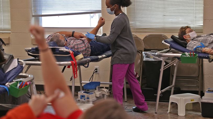 People donate blood during a blood drive Monday at the Father Paul Vieson Center in New Carlisle. BILL LACKEY/STAFF