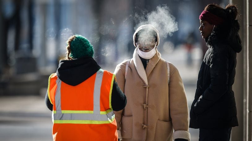 Pedestrians walk in downtown Dayton on a frigid morning. Jim Noelker/Staff
