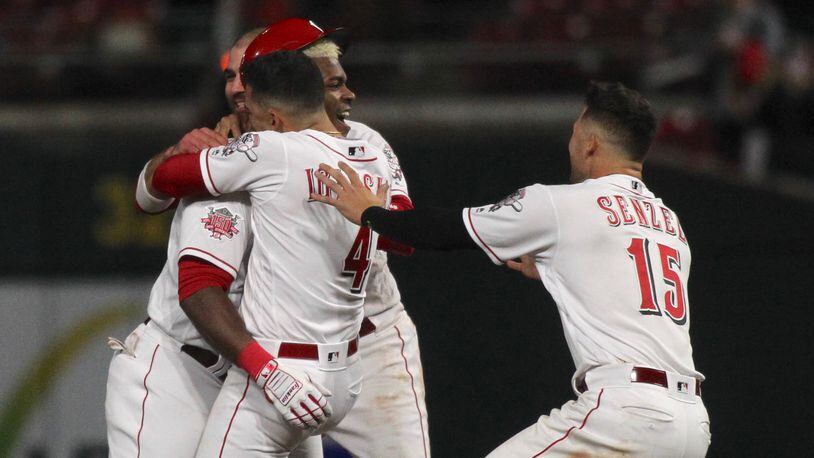 The Reds celebrate a walk-off, bases-loaded RBI single by Yasiel Puig in the 10th inning against the Cubs on Wednesday, May 15, 2019, at Great American Ball Park in Cincinnati.