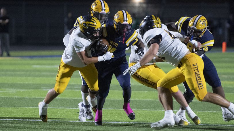 Centerville's defense, led by Landon King (left) and Mason Keely (right) bring down Springfield running back Deontre Long Friday night at Springfield. Logan Howard/CONTRIBUTED