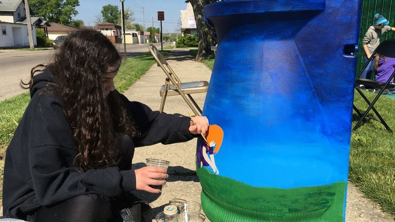 Jennah Kuhn, a Northridge Middle School student, paints a rain barrel that will be raffled at the unveiling of Project Jericho s Catching Light mural unveiling at the Clark County Solid Waste District Building on W. Main St. Contributed photo