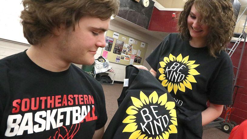 Mozie Van Raaij, a student at Southeastern High School, gives fellow student,Camden Snodgrass, a “Be Kind” t-shirt in class Friday, April 20, 2018. Mozie gave out 200 of the t-shirts after finding an offensive message writen in the locker room recently. BILL LACKEY/STAFF
