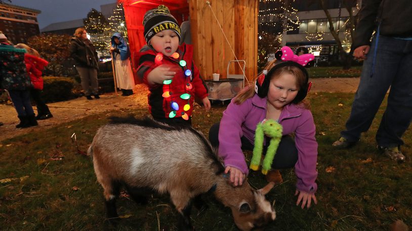 Joshua Hennis, 3, and his sister, Shellie, 7, pet a goat that was part of the live nativity scene at the 2018 Holiday in the City Festival. BILL LACKEY/STAFF