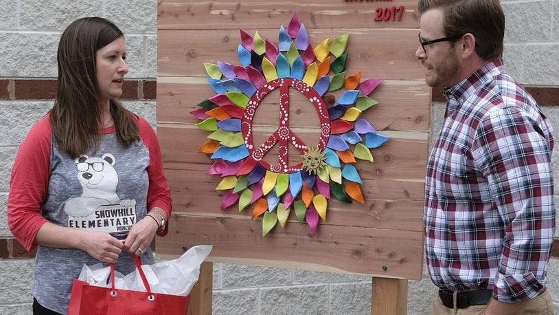 Jennifer Paxson, principal of Snowhill Elementary, talks to artist Jeremy Block, who made the piece of artwork for the front of the school Thursday. The art piece was unveiled during a reception after school. Bill Lackey/Staff