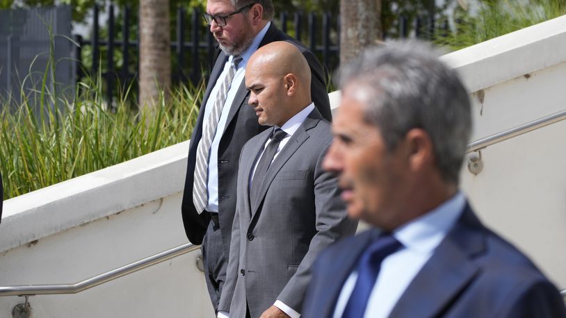 FILE - Walt Nauta, center, valet to former president Donald Trump, his attorney Stanley Woodward, rear, and Carlos De Oliveira, foreground, the property manager of Trump's Mar-a-Lago estate, leave the Alto Lee Adams Sr. U.S. Courthouse, Aug. 10, 2023, in Fort Pierce, Fla. Lawyers for Nauta and De Oliveira are set to ask U.S. District Judge Aileen Cannon during a Frida, April 12, 2024, hearing to throw out charges of conspiring with Trump to obstruct an FBI investigation into the hoarding of classified documents at the former president's Palm Beach estate. (AP Photo/Wilfredo Lee, File)
