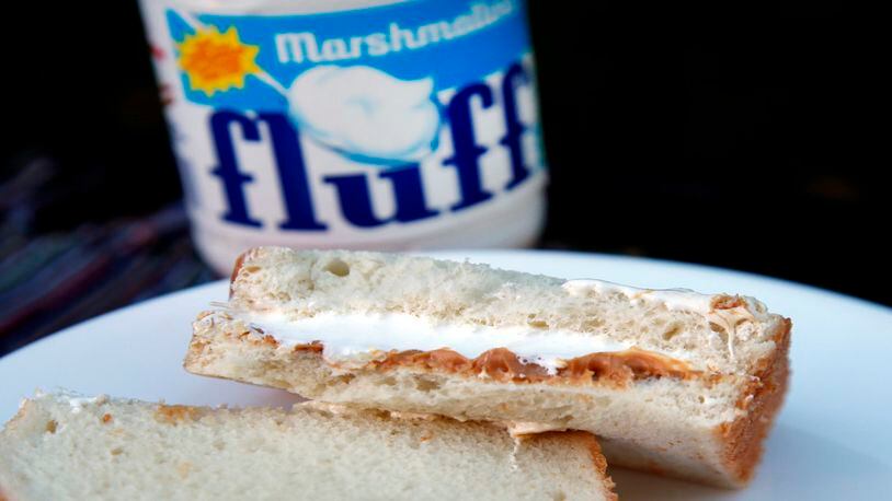 In this Sept. 27, 2013, file photo, a jar of Marshmallow Fluff and a Fluffernutter sandwich are displayed in North Andover, Mass. Archibald Query invented Fluff in 1917 in the Boston suburb of Somerville. The marshmallow concoction that's been smeared on a century's worth of sandwiches has inspired a festival and other sticky remembrances as it turns 100 in 2017. (AP Photo/Elise Amendola, File)