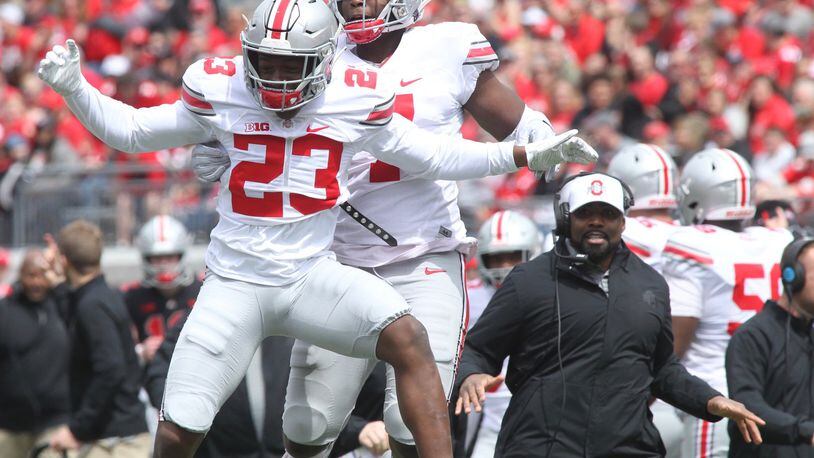 Ohio State’ Jahsen Wint (23) celebrates after intercepting a pass with Teradja Mitchell during the spring game on Saturday, April 13, 2019, at Ohio Stadium in Columbus. David Jablonski/Staff