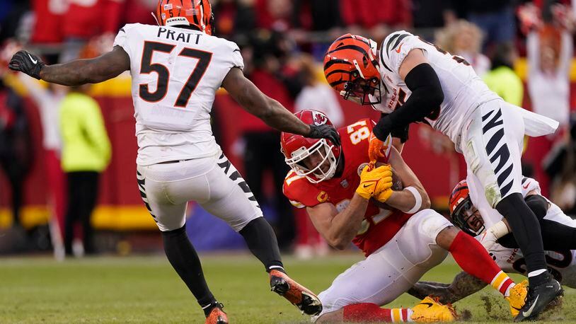 Kansas City Chiefs tight end Travis Kelce (87) catches a pass between Cincinnati Bengals linebacker Germaine Pratt (57) and linebacker Logan Wilson, right, during the second half of the AFC championship NFL football game, Sunday, Jan. 30, 2022, in Kansas City, Mo. (AP Photo/Charlie Riedel)