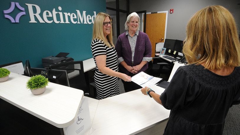 RetireMed staff from left, Mindy Berry and Cynthia Requarth talk with Becky Volz in their office located at 9080 Springboro Pike in Miamisburg. MARSHALL GORBY\STAFF