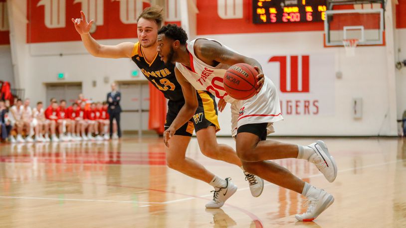 Wittenberg University’s James Johnson drives past Wooster’s Peyton Bennington during the North Coast Athletic Conference Tournament championship game on Saturday afternoon at Pam Evans Smith Arena. CONTRIBUTED PHOTO BY MICHAEL COOPER