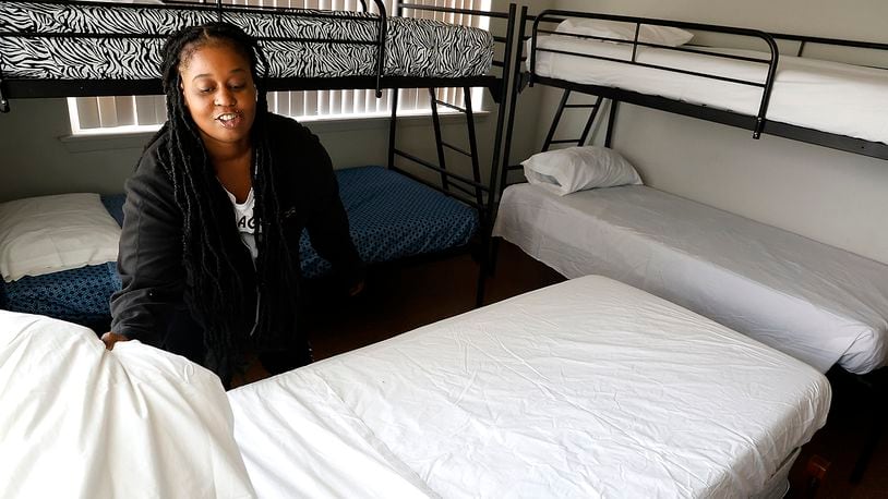 Taylor Cobb makes the beds in one of the family size rooms Tuesday, Sept. 5, 2023 as she helps get Norm's Place homeless shelter ready to reopen. BILL LACKEY/STAFF