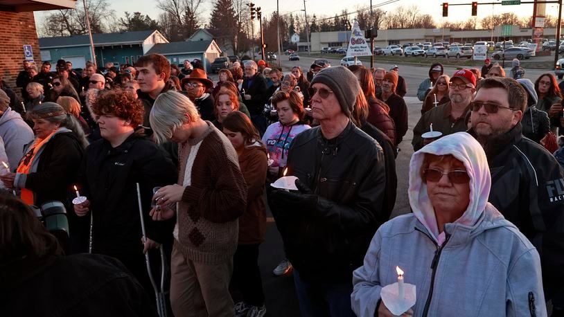 People fill the parking lot of Gill's Quality Meat Market Monday, Jan. 9, 2023 during a candle light vigil for Thomas Gill, who was shot and killed in January while driving his SUV in Springfield. BILL LACKEY/STAFF