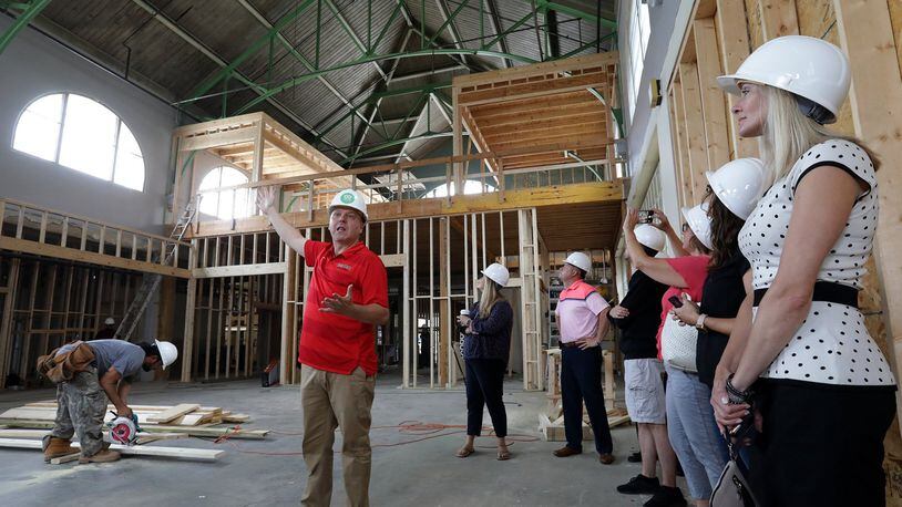 Patrick Williams leads a tour of the new COhatch Market to show investors and city officials the progress of the construction Wednesday. BILL LACKEY/STAFF
