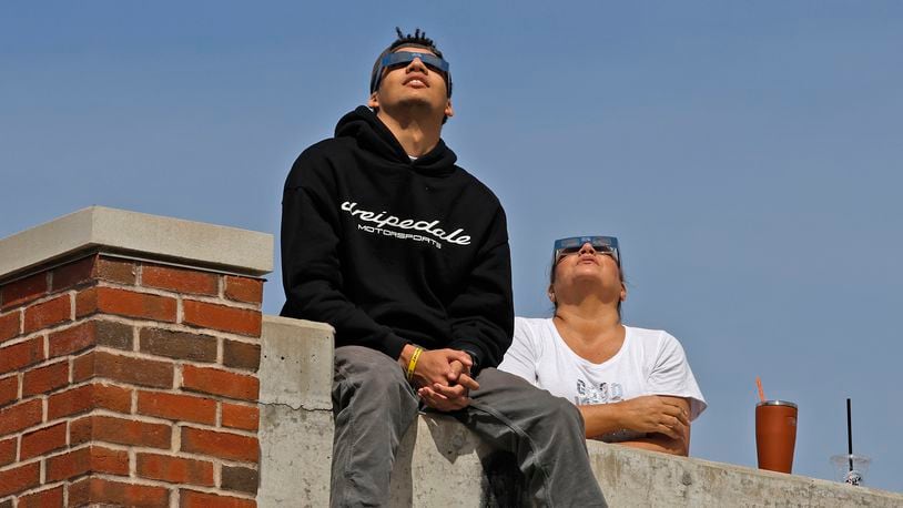 People watch the solar eclipse Monday, April 8, 2024 from the top of the Springfield parking garage. BILL LACKEY/STAFF
