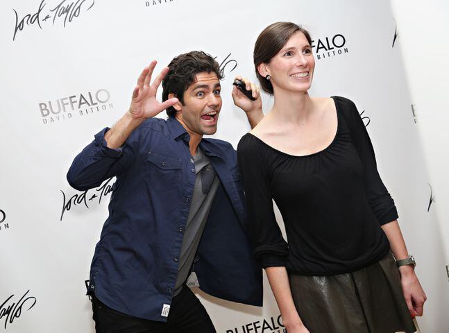 Adrian Grenier (L) photobombs a guest