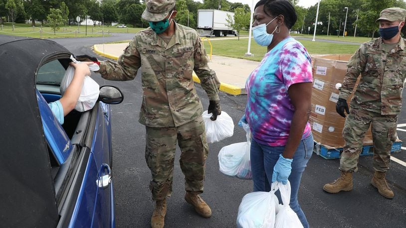 Leigh Stowers, along with Sgt. Raishan Magby, left, and SrA James Fulton of the National Guard, pass out food during the Summer Food Program at Fulton Elementary School in 2020. This year's Summer Food Program kicks off this week and will run through August. BILL LACKEY/STAFF
