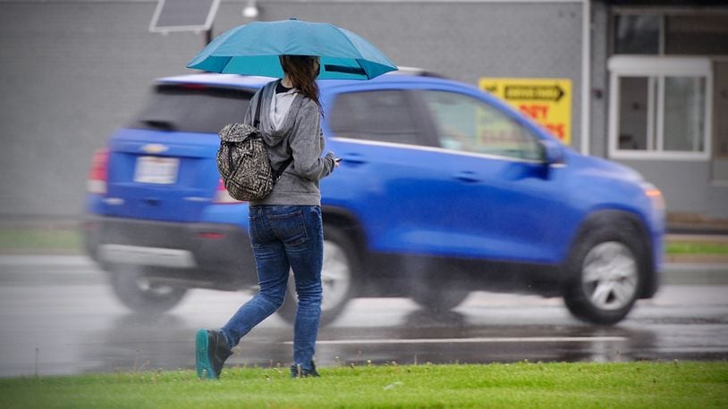 It's a good day to have a umbrella if you're out and about. Here is a person walking on N. Dixie Dr. Thursday April 29, 2021. There will be showers and storms most of the day.